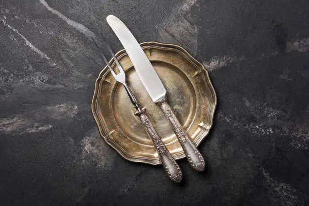 Top view of antique silver-plated cutlery or silverware on black marble background