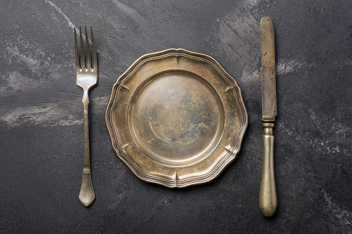 Top view of antique silver-plated cutlery or silverware on black marble background