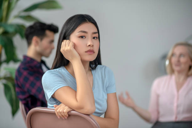 istock Long-haired asian girl siting and looking aside 1215087061