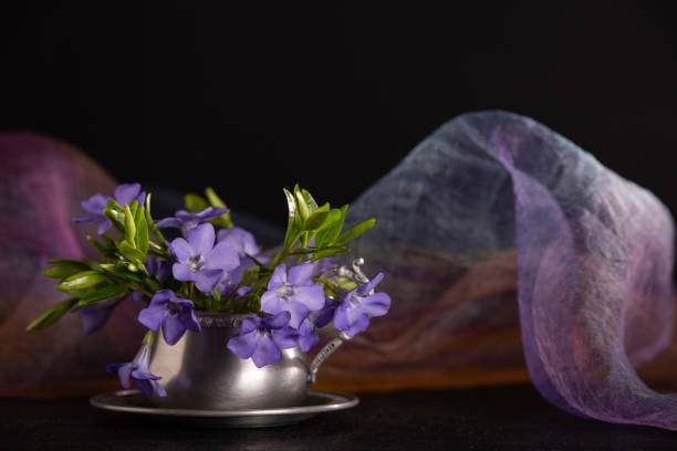 Bunch of beautiful spring flowers in a cup on a dark background