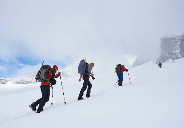 istock Group of hikers climbing the hill covered with snow. 1215088594