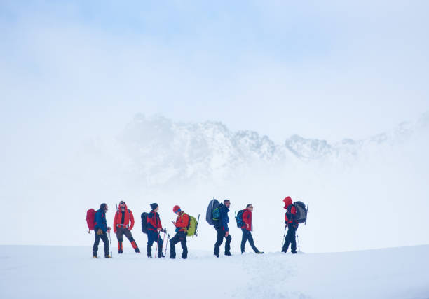 istock Travelers standing on snowy field in mountains. 1215088902
