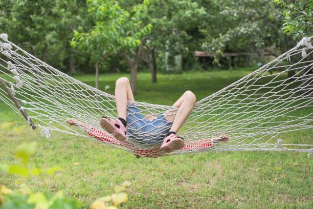 istock Child girl falling from hammock, spring garden background 1215091318