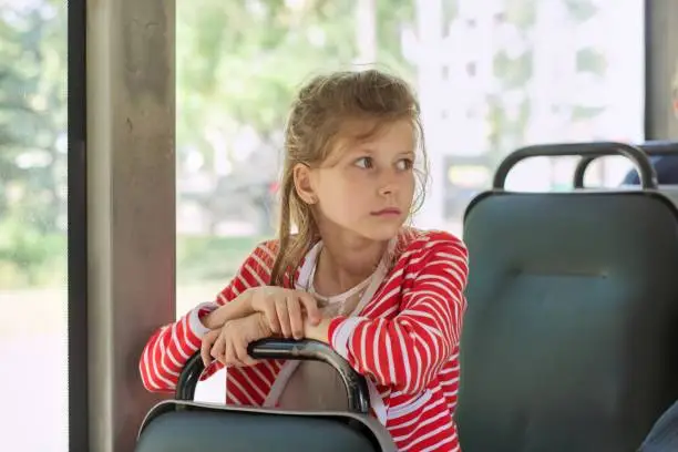 Child passenger of city bus, trolleybus, girl sitting in the passenger seat