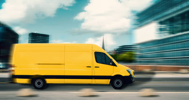 istock Fast mail and parcel delivery, yellow mail car in a modern city. With motion blur, delivery truck in side view. 1215092477