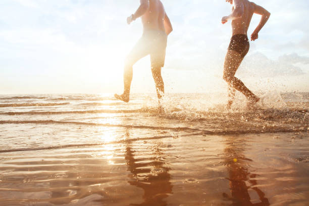 istock friends having fun in the sea at sunset beach 1215093479