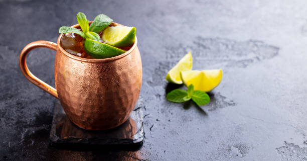 istock Moscow Mules cocktail with ginger beer, vodka, lime and mint. Black background. Copy space. Close up. 1215094891