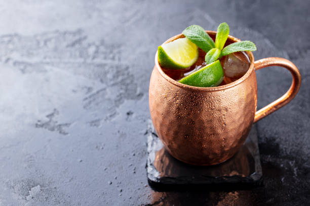 istock Cold Moscow Mules cocktail with ginger beer, vodka, lime. Grey stone background. Copy space. 1215095155