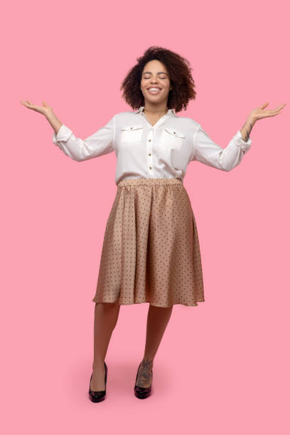 Smiling young woman standing with her eyes closed.