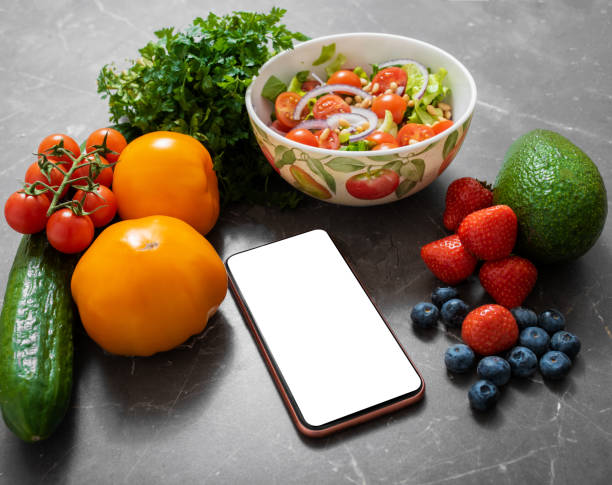 istock Smartphone on a kitchen table surrounded by vegetables and fruits 1215095491