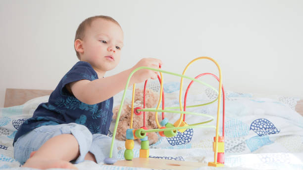 istock Cute small toddler doing brain exercises. Baby boy playing development montessori games. 1215095640