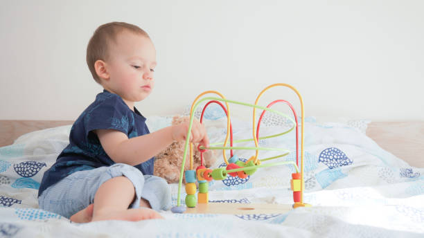 istock Cute small toddler doing brain exercises. Baby boy playing development montessori games. 1215095670