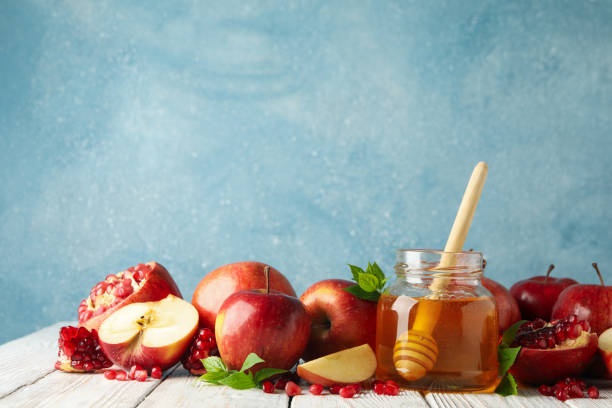 istock Apples, pomegranate and honey on wooden table, space for text 1215096276