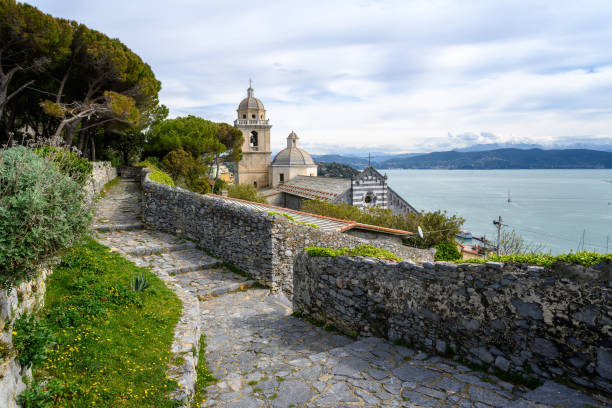 A view from the grounds of Doria Castle towards the Church of San Lorenzo(Chiesa di San Lorenzo) with view on the Bay of Poets in Porto Venere, Italy