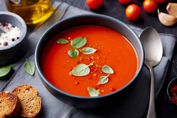 istock Tomato soup with basil in a bowl. Dark background. Close up. 1215096500