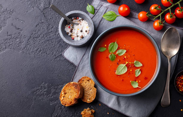 istock Tomato soup with basil in a bowl. Dark background. Copy space. Top view. 1215096675
