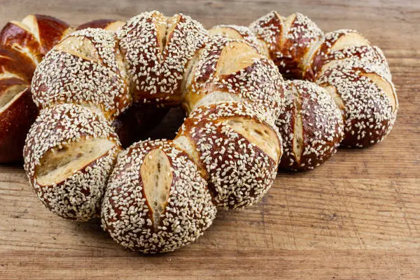 Photo of lye kringle with sesame on a wooden board