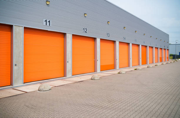 istock warehouses with orange roller doors 1215098620