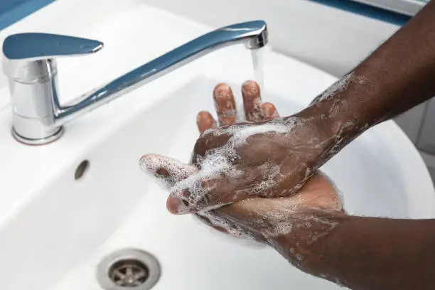 Photo of Man washing hands carefully in bathroom close up. Prevention of infection and pneumonia virus spreading