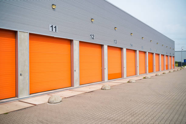 istock warehouses with orange roller doors 1215099200