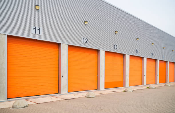 istock warehouses with orange roller doors 1215099205