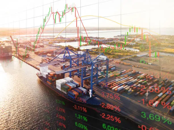 Volatile market stock data: overlay of mostly red changing numbers and bearish graph with container ship and cargo containers. This theme goes hand in hand with the global impact of the coronavirus covid-19 on the global economy and trade