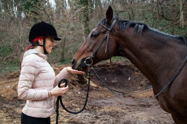 istock Young farmer woman playing with her horse 1215100054