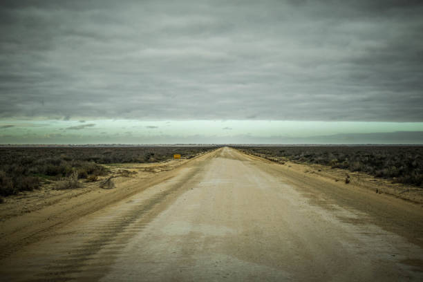 A deserted road in a sandstorm runs along the Eastern Sahara Desert between the White Desert and the Black Desert in Egypt.