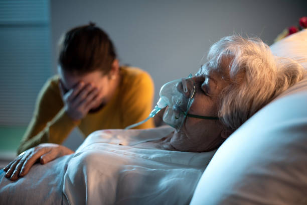 Daughter assisting her mother at the hospital Sad daughter assisting her senior ill mother at the hospital, she is sitting next to her Oxygen stock pictures, royalty-free photos & images