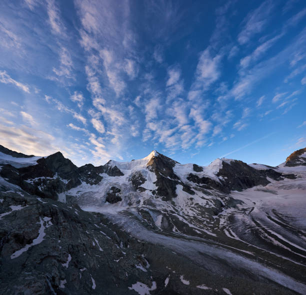 Amazing breathtaking scenery in sunny day with blue sky and clouds, beautiful mountains area with snow. Gorgeous mountain ridge with high rocky peaks, wonderland.
