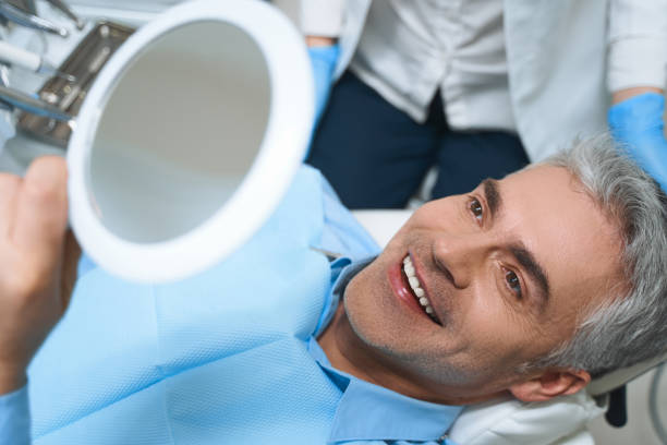homme heureux après la photo de stock de procédures dentaires - implant photos et images de collection