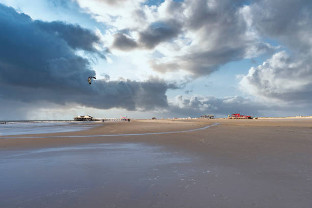 свая домов и кайт-серферов на пляже санкт-питер-ординг - wadden wadden sea unesco world heritage site sea стоковые фото и изображения