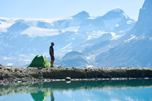 istock Man enjoying mountains landscape near tent. 1215113317