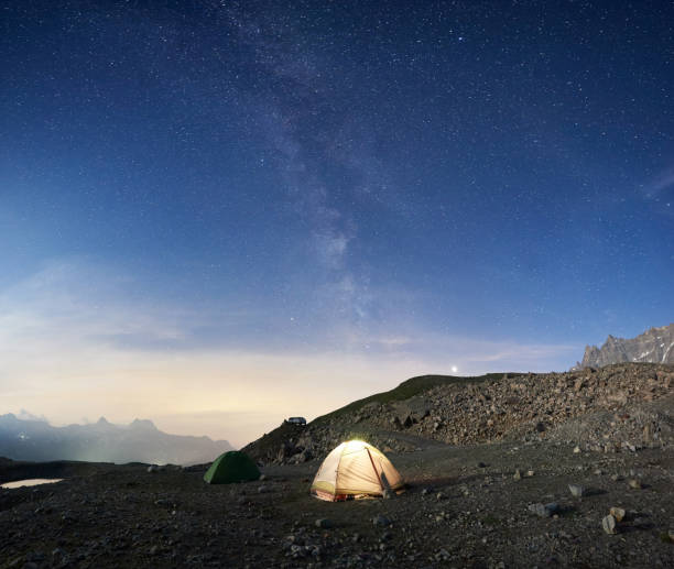 istock Camp tents in mountains under starry sky. 1215114967