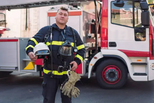 Photo of Portrait of confident mid adult firefighter on duty