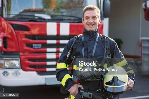 istock Portrait of cheerful mid adult firefighter on duty 1215115653
