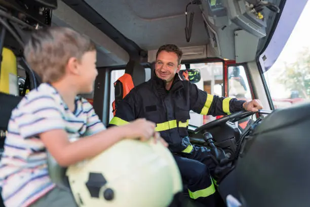 Photo of Little boy meeting real firefighter