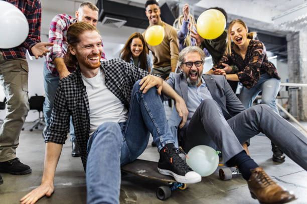 istock Cheerful freelancers having fun during skateboard competition at casual office. 1215116883