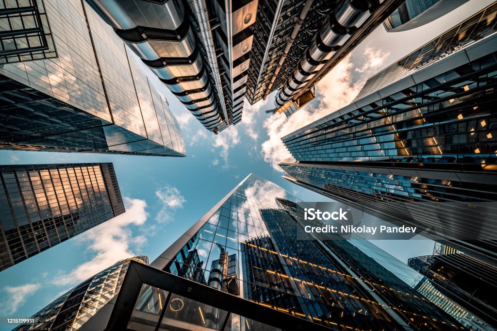 Looking directly up at the skyline of the financial district in central London - stock image Highly detailed abstract wide angle view up towards the sky in the financial district of London City and its ultra modern contemporary buildings with unique architecture. Shot on Canon EOS R full frame with 10mm wide angle lens. Image is ideal for background. Business Stock Photo