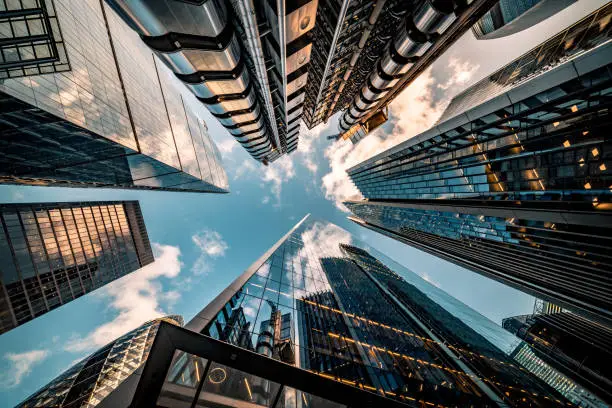 Highly detailed abstract wide angle view up towards the sky in the financial district of London City and its ultra modern contemporary buildings with unique architecture. Shot on Canon EOS R full frame with 10mm wide angle lens. Image is ideal for background.