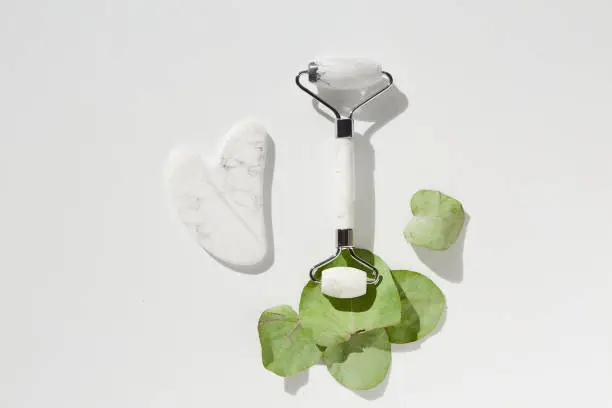 Photo of Jade face beauty roller gua Sha massage. Flat lay. Beauty blog advertising. Chinese Eastern medicine concept.