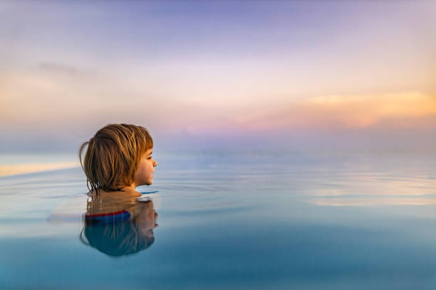 istock Profile view of cute little boy in the infinity pool. 1215123385