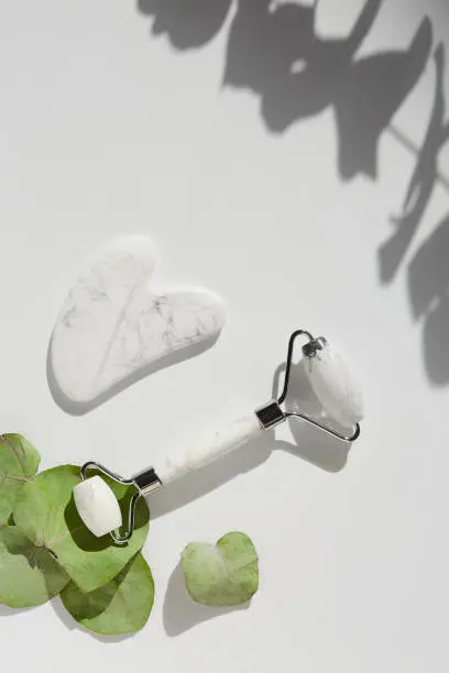 Photo of Jade face beauty roller gua Sha massage. Flat lay. Beauty blog advertising. Chinese Eastern medicine concept.