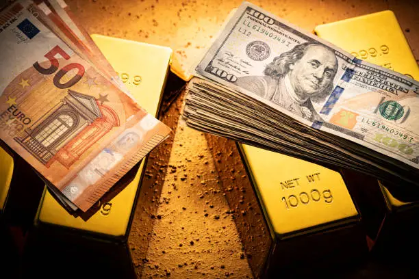 Gold bars and fiat money 100 Dollar note and Euro financial concept arrangement