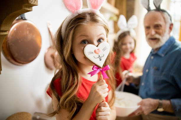 Fake nose for cute bunny stock photo Adorable girl wearing bunny ears and putting a gingerbread nose in front of her face easter stock pictures, royalty-free photos & images