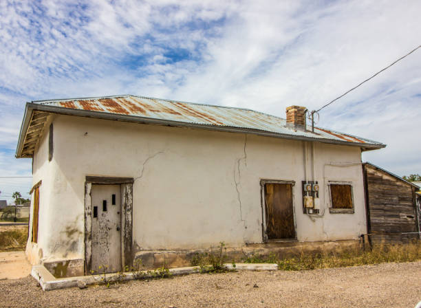 istock Old Weathered Stucco Building With Boarded Up Window 1215130894