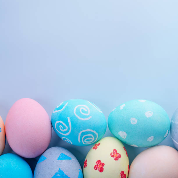 istock Colorful Easter hunting eggs dyed by colored water with beautiful pattern on pastel blue background, design concept of holiday, top view, copy space. 1215130929