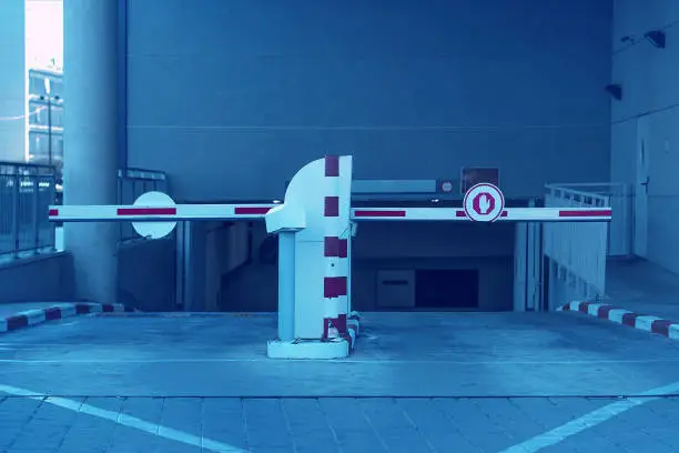 Barrier at Entrance and exit of a car Parking garage. barrier in a car park. Exit from underground parking. Underground parking/garage. Interior of parking. Blue toning