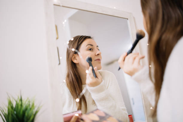 istock Woman contouring her face using brush and highlighters 1215133801