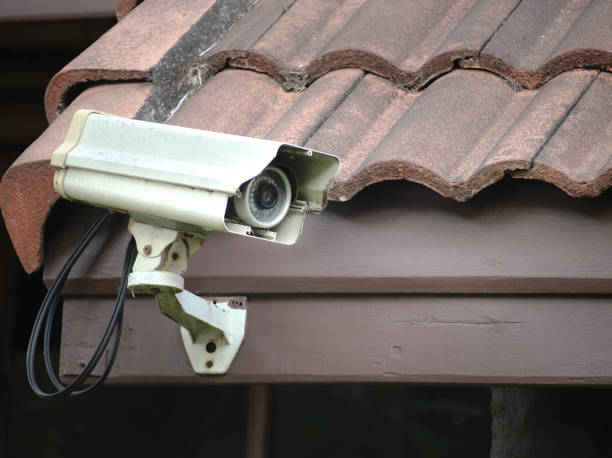 istock Old security camera or CCTV installed on the house roof. 1215138050